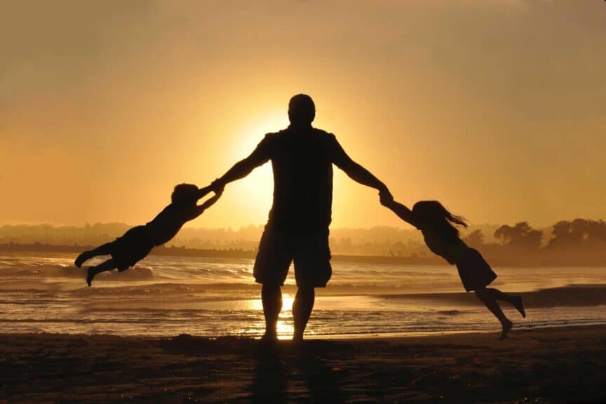 father-kids-beach-ocean-sunset-shadows