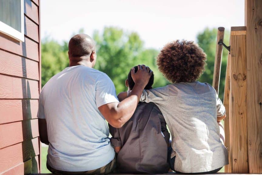 father-with-children-sitting-backyard