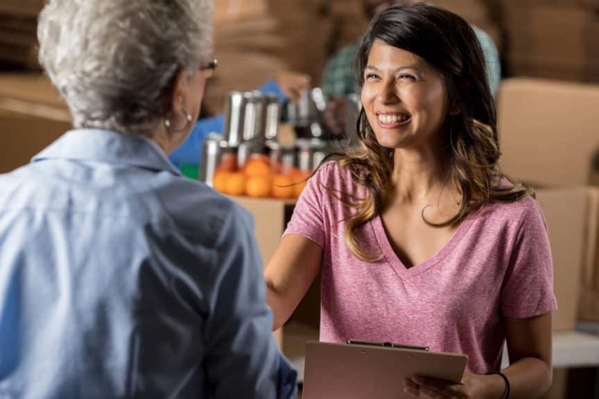 food-bank-organizer-greets-senior-volunteer