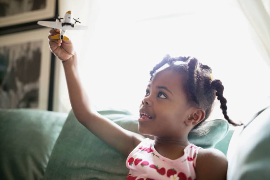 Girl flying toy airplane