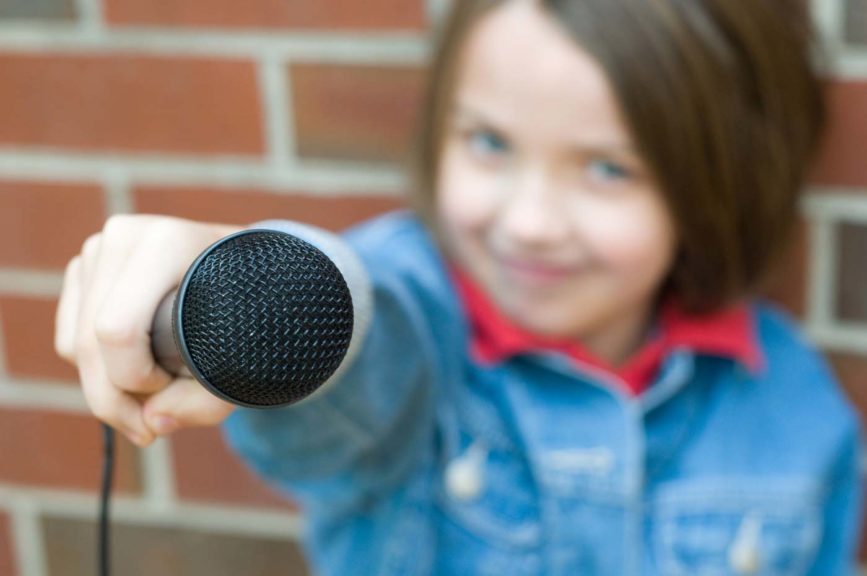 girl holding a microphone up to the camera