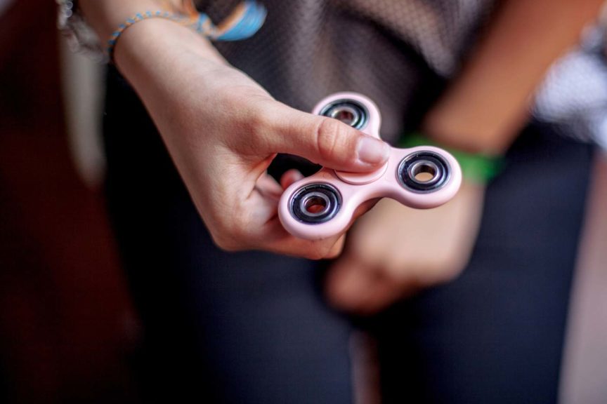 Teen girl playing with spinner toy
