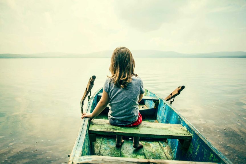 Girl sitting in boat on lake