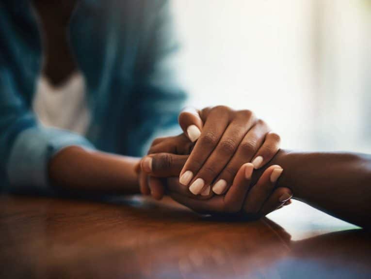 two people holding hands across a desk