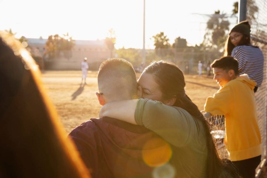 happy-mother-son-hugging-baseball-game