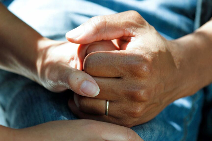 Married couple holding hands for comfort