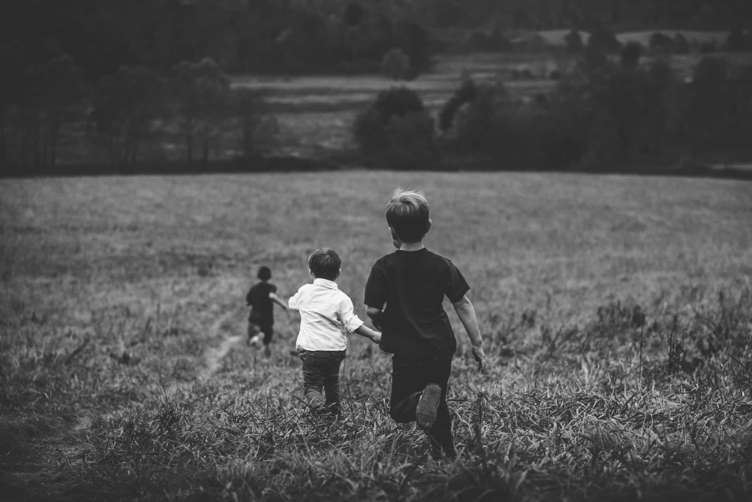 three boys running down hill