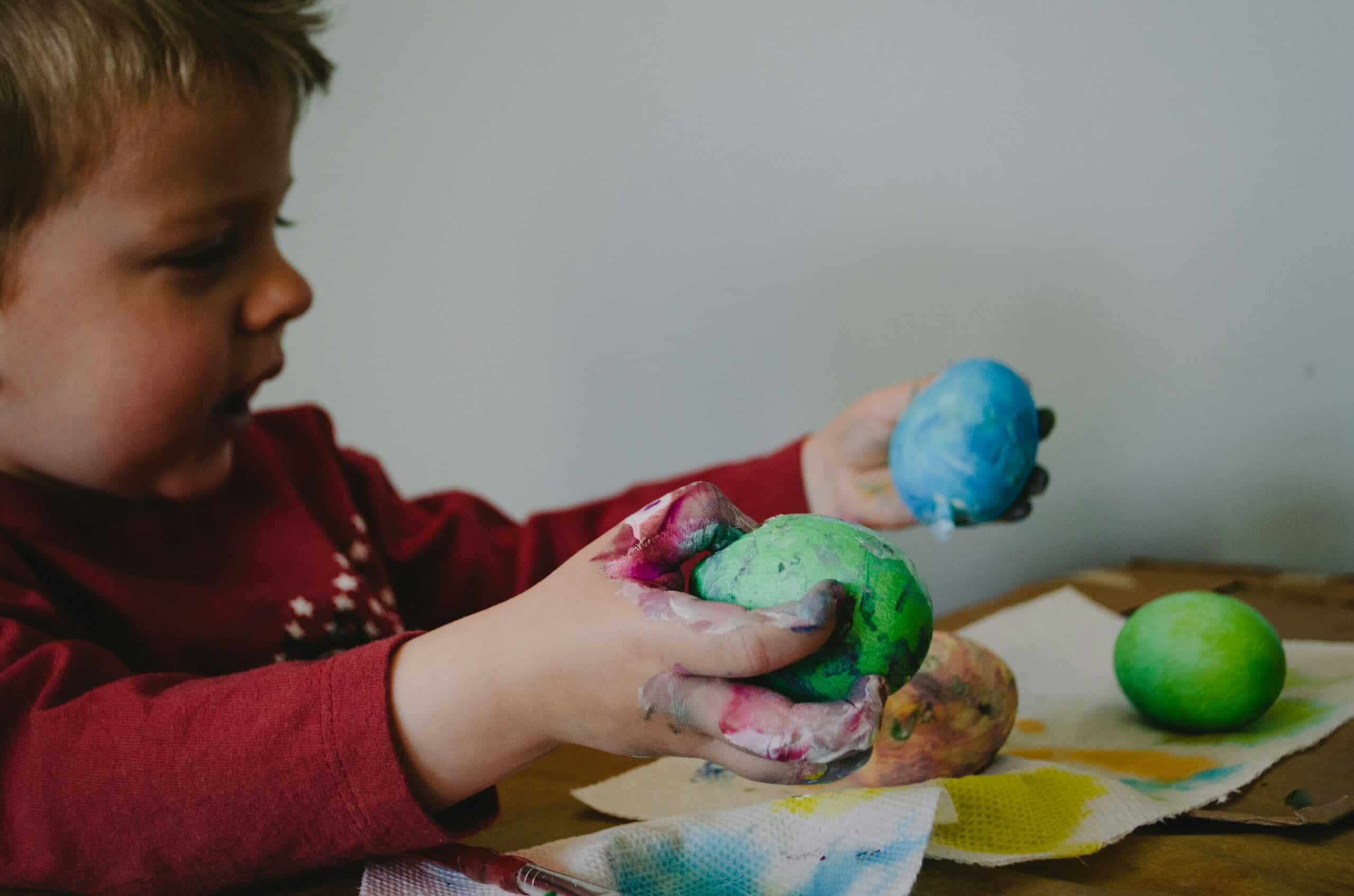 toddler boy playing with messy crafts
