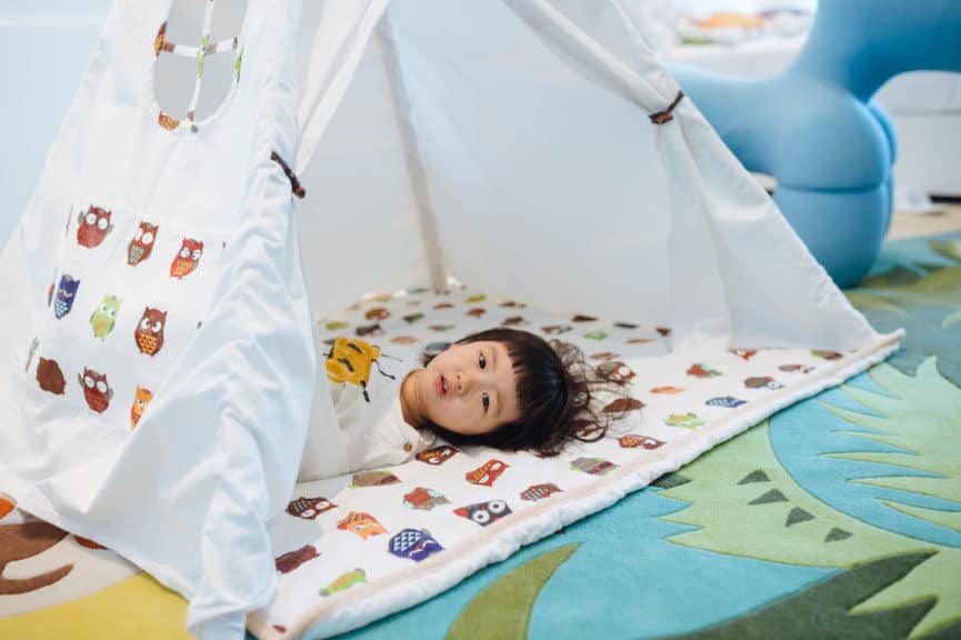 A little girl was lying in the small tent 