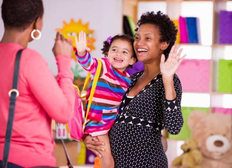 Mother and child waving to teacher