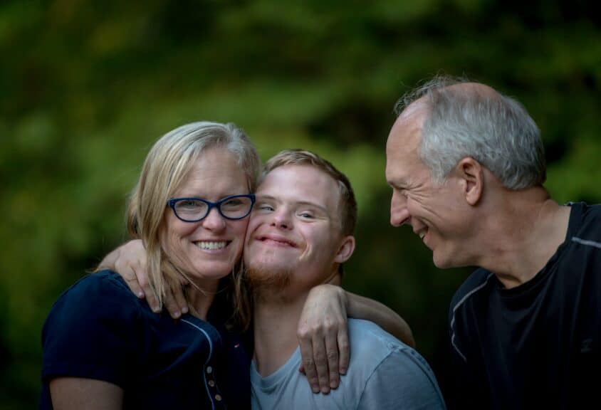 parents hugging down syndrome son