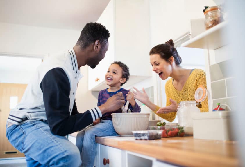 Parents and toddler son baking in kitchen