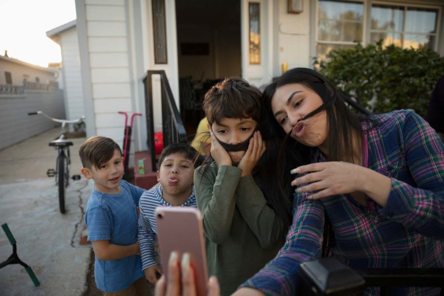 Playful mother and sons taking selfie