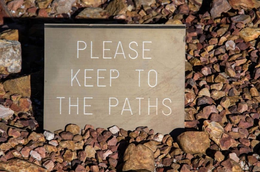 'Please keep to the paths' warning sign in a garden bed