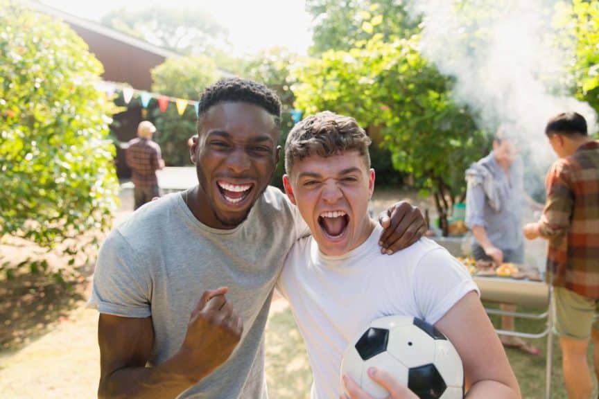 portrait-enthusiastic-men-soccerball-cheering-bbq