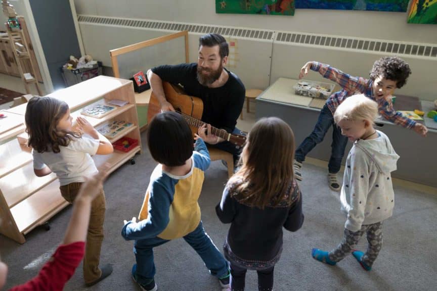 preschool-students-dancing-teacher-guitar-classroom