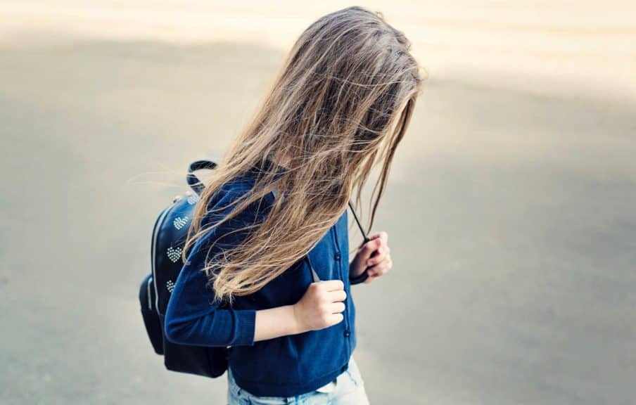 sad girl walking brown hair with backpack
