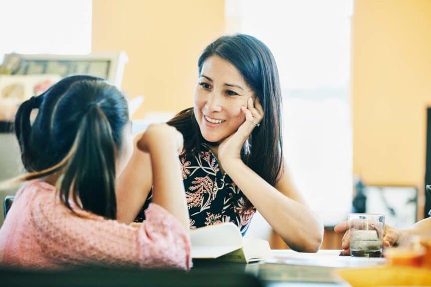 similing-mother-discussion-daughter-homework-kitchen