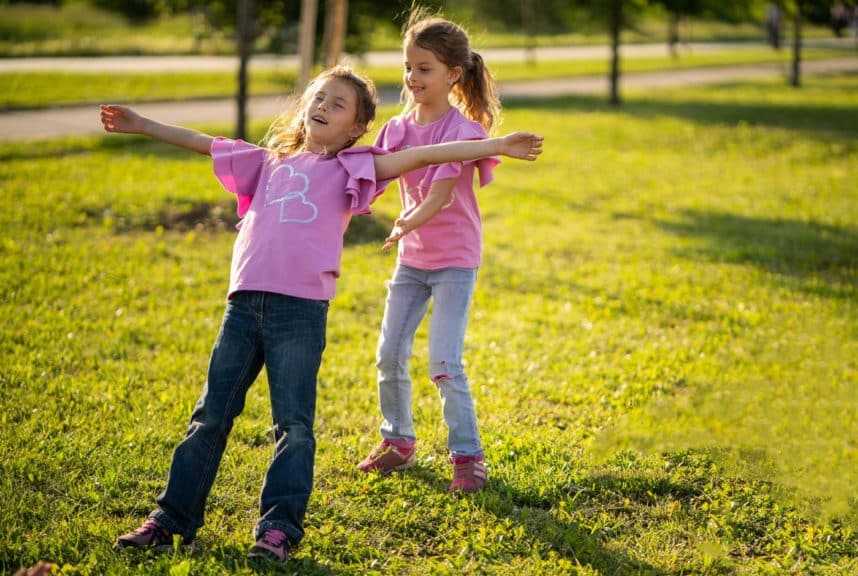 sisters-playing-in-yard-falling-back