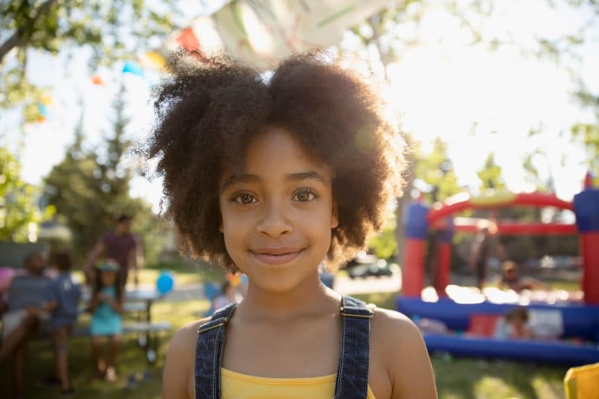 Portrait smiling, cute girl at summer neighborhood block party in park