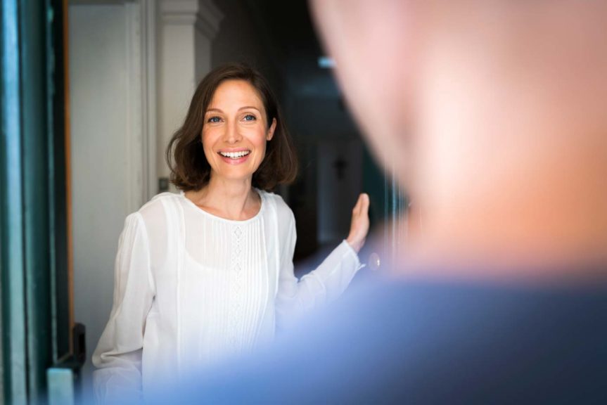 Smiling mid adult woman standing on entrance