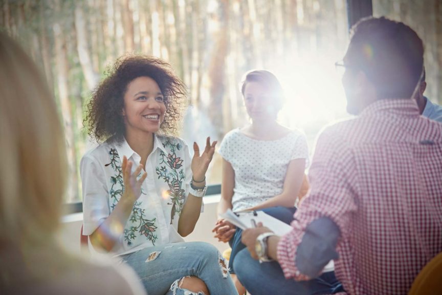 smiling-woman-talking-group-therapy-session