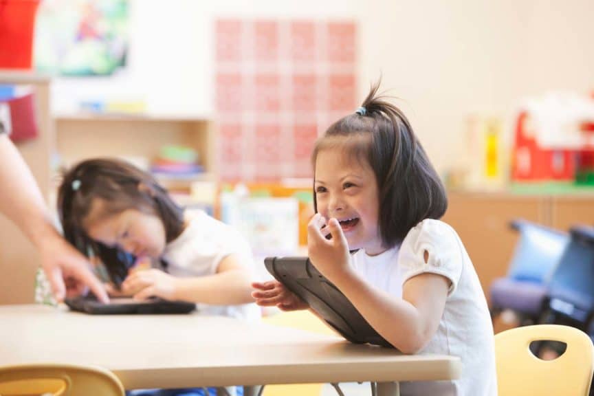 Special needs girl using tablet in classroom