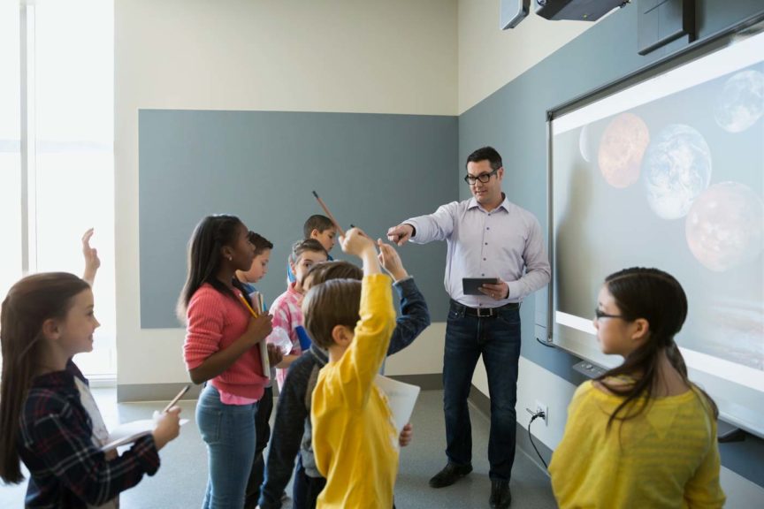 Students asking questions of teacher leading astronomy lesson