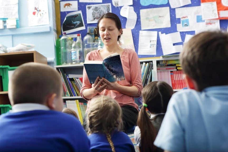 teacher reading elementary students