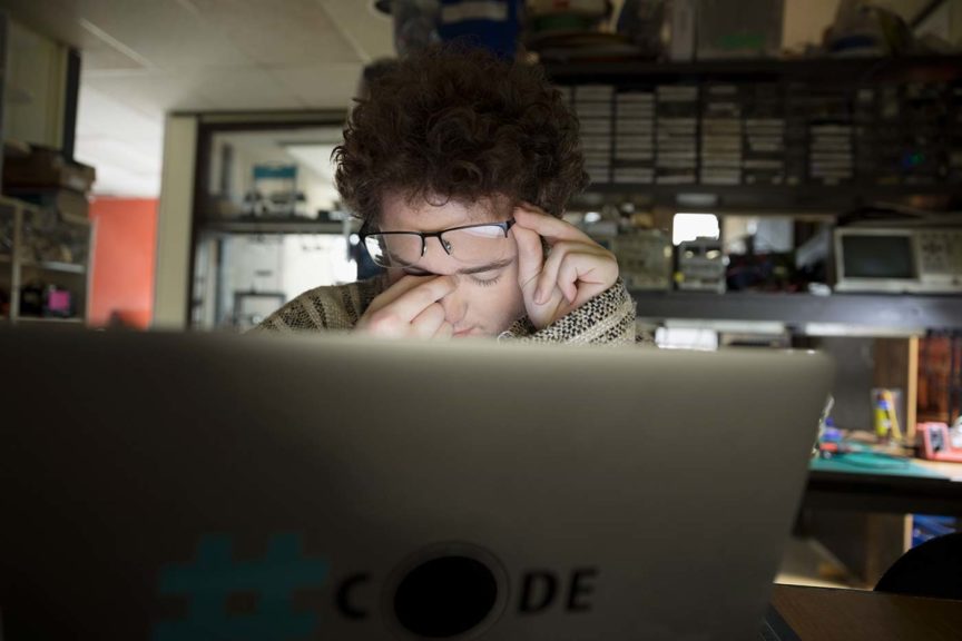 depressed teenage boy using computer