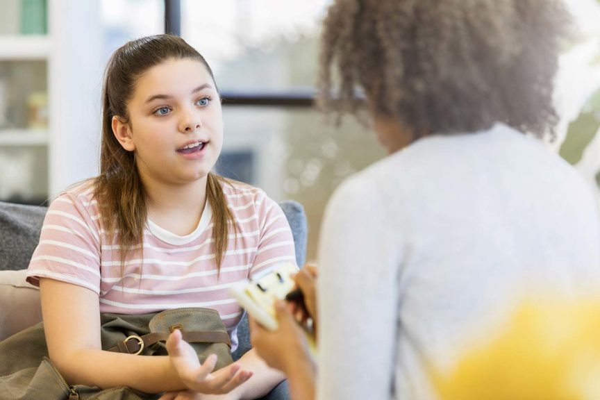 depressed teenage girl talking with counselor