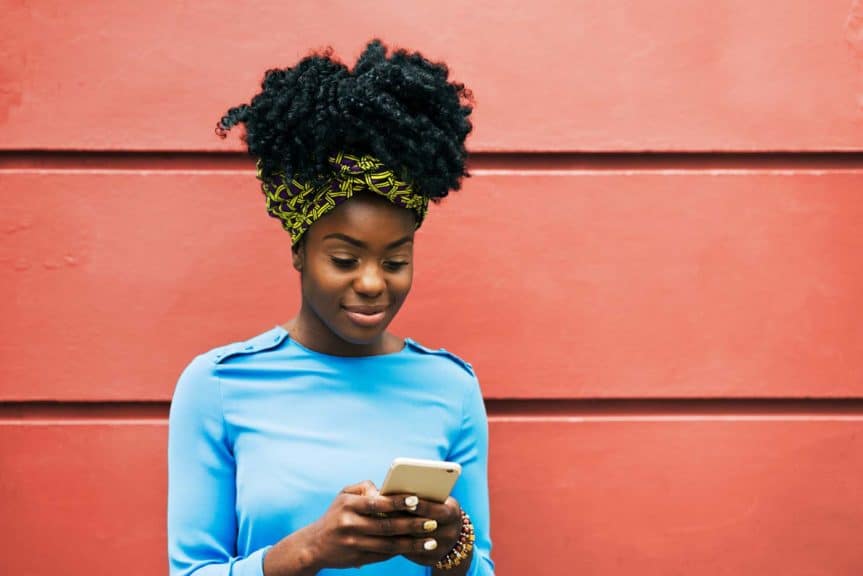 Woman using phone with red background