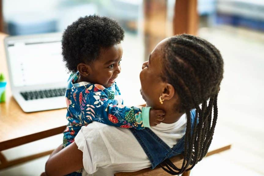 Woman with baby son sitting at table at home