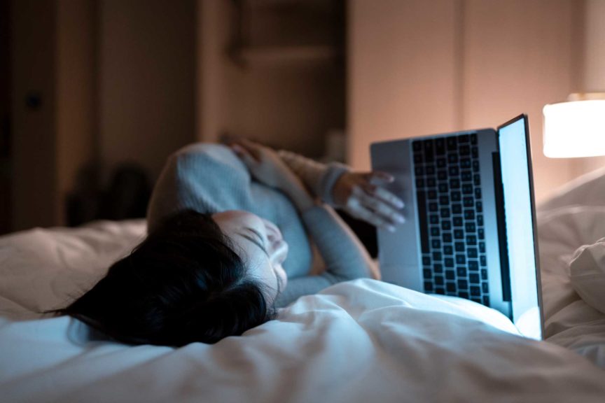 woman working with laptop on the bed