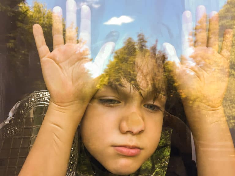 Young boy smashing face against window